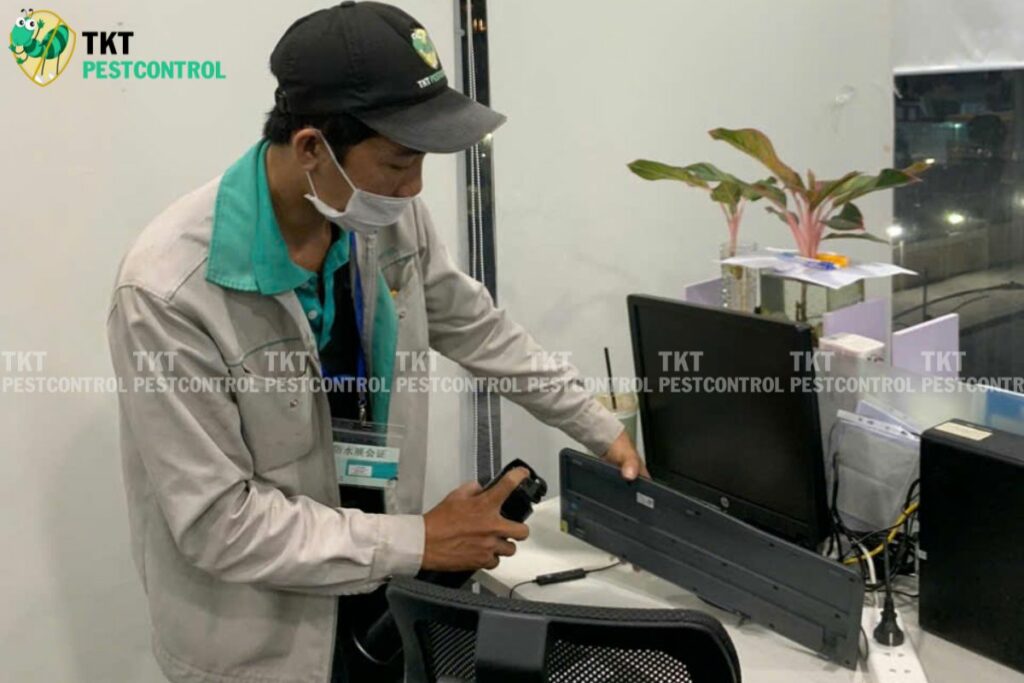 employee spraying mosquito repellent at desk